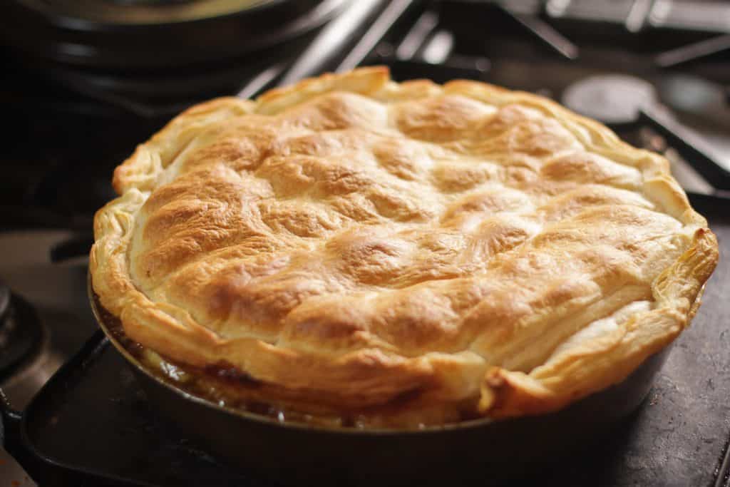 A whole golden pie with a crimped pastry top