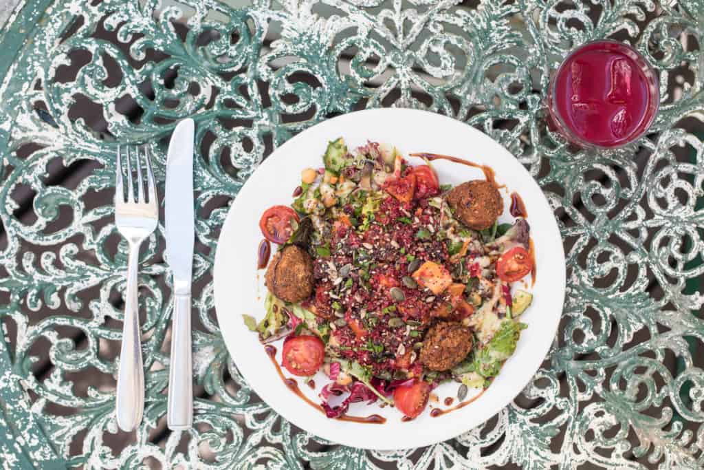 A colourful vegetable or grain salad on an outdoor metal table